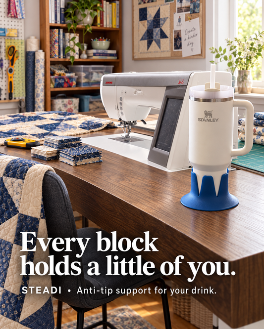 Blue Steadi supporting a handled tumbler on a wooden sewing table near a sewing machine and quilt fabric. Illustrative AI-generated scene.